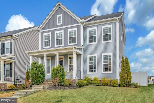 view of front facade featuring a porch, board and batten siding, and a front yard