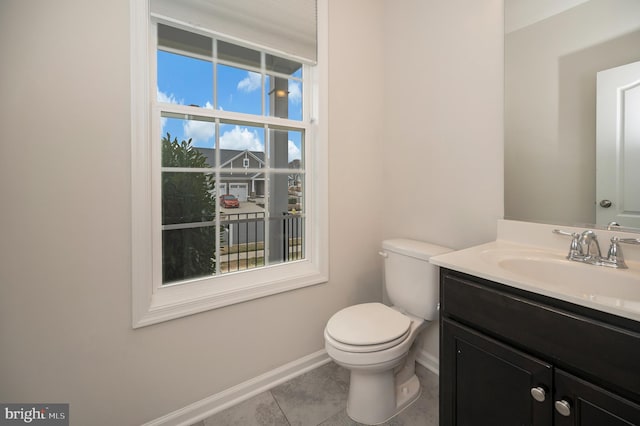 half bathroom featuring baseboards, tile patterned floors, vanity, and toilet