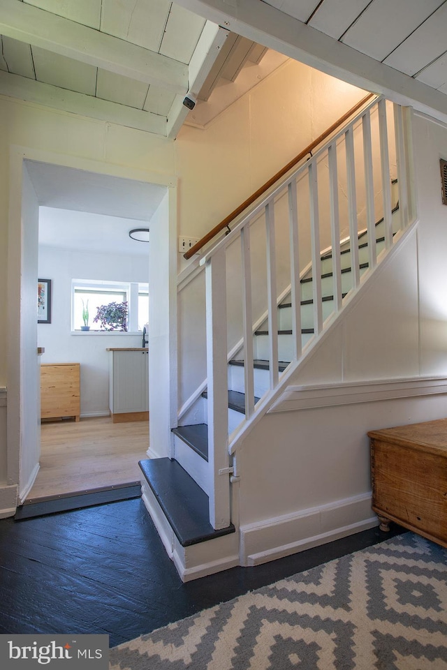 stairs featuring baseboards, visible vents, and wood finished floors