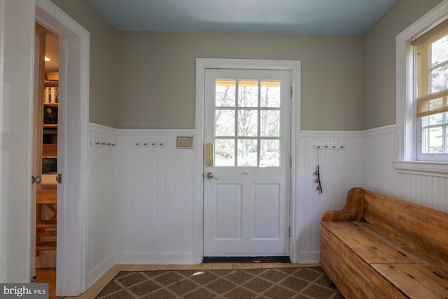 doorway to outside featuring a wainscoted wall