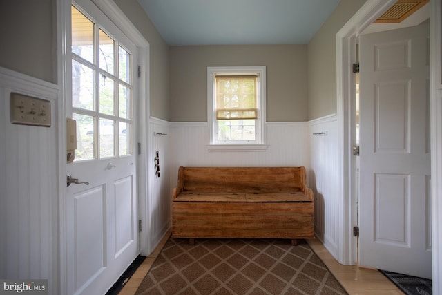 living area with a wainscoted wall and visible vents