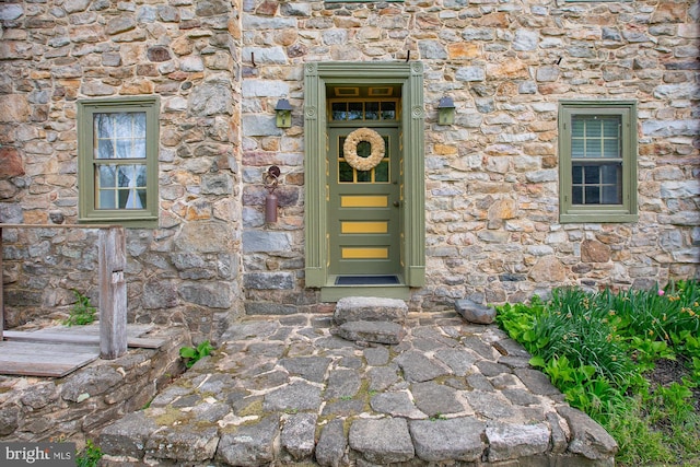 doorway to property featuring stone siding