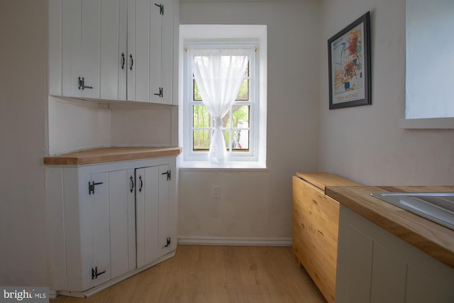interior space featuring baseboards and light wood finished floors