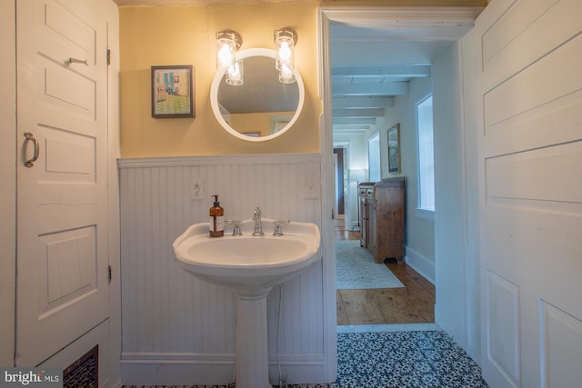bathroom with a sink and a wainscoted wall