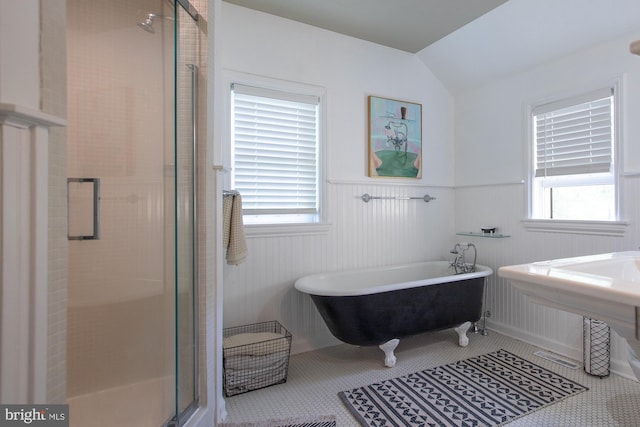 bathroom with a freestanding bath, wainscoting, a stall shower, and a wealth of natural light