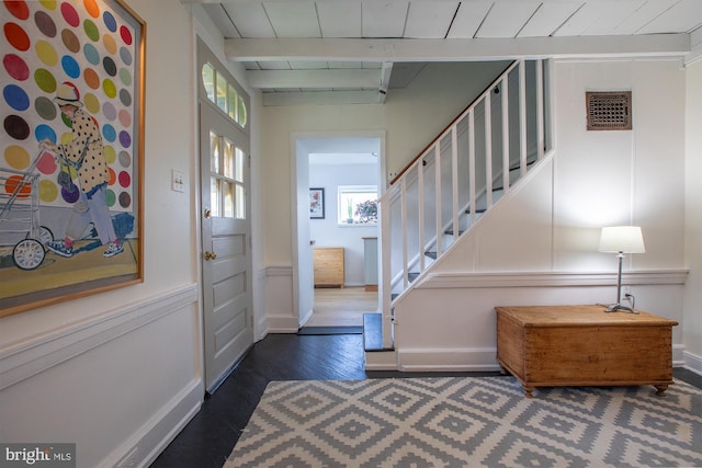 entryway with stairway, baseboards, dark wood-style floors, and visible vents