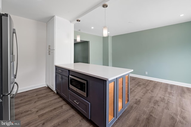 kitchen featuring stainless steel appliances, dark wood-type flooring, a peninsula, light countertops, and recessed lighting