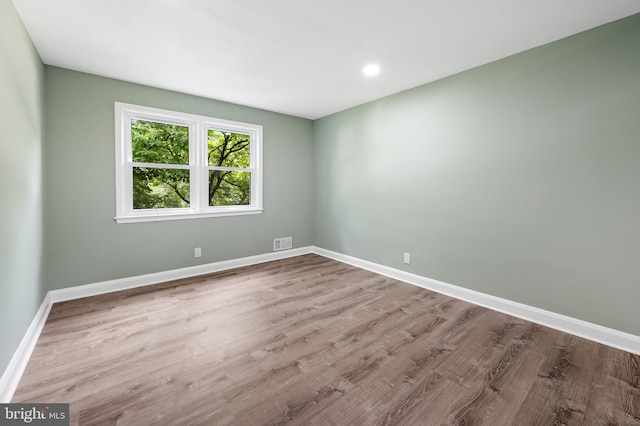 unfurnished room featuring baseboards, wood finished floors, and recessed lighting