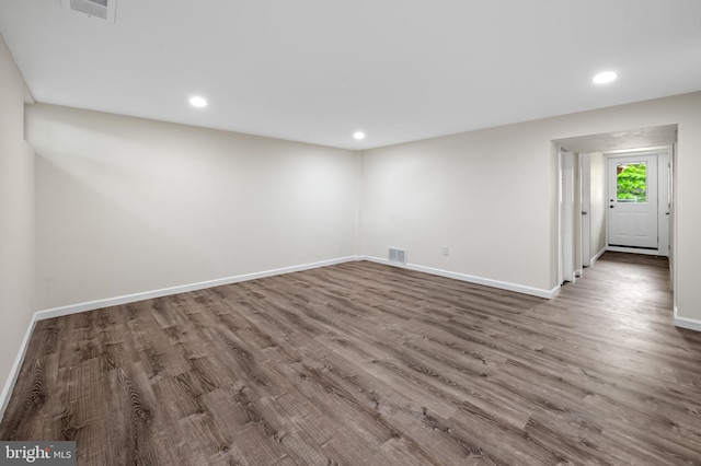 unfurnished room with wood finished floors, baseboards, and recessed lighting