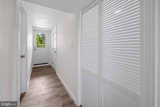 hall with light wood-type flooring and baseboards