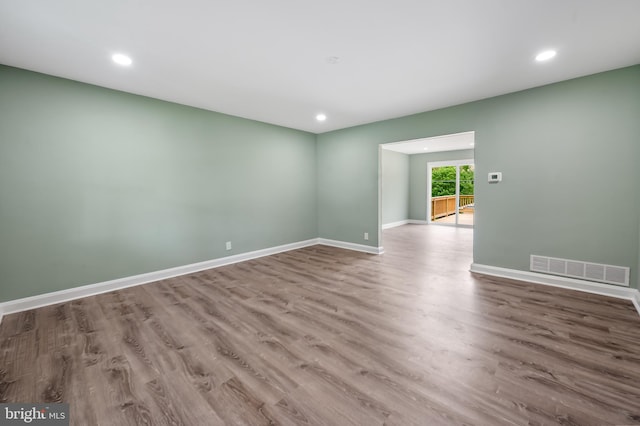 spare room featuring wood finished floors, baseboards, and recessed lighting