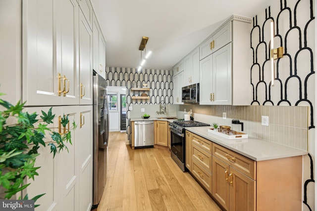 kitchen with appliances with stainless steel finishes, light wood-style flooring, and light countertops