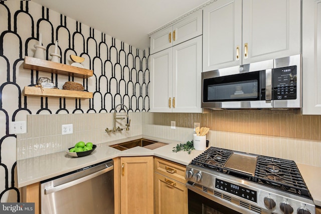 kitchen featuring stainless steel appliances, open shelves, decorative backsplash, light countertops, and a sink
