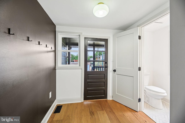 doorway featuring light wood-style flooring and baseboards