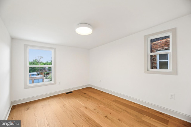 empty room featuring light wood finished floors and baseboards