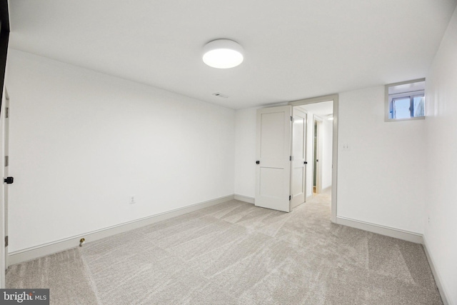 unfurnished room with light carpet and baseboards