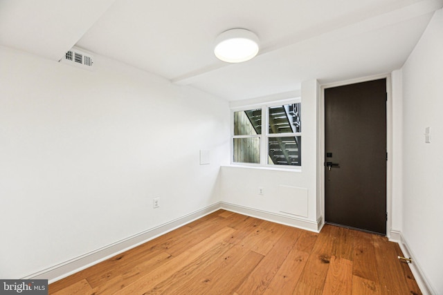 empty room featuring light wood finished floors and baseboards
