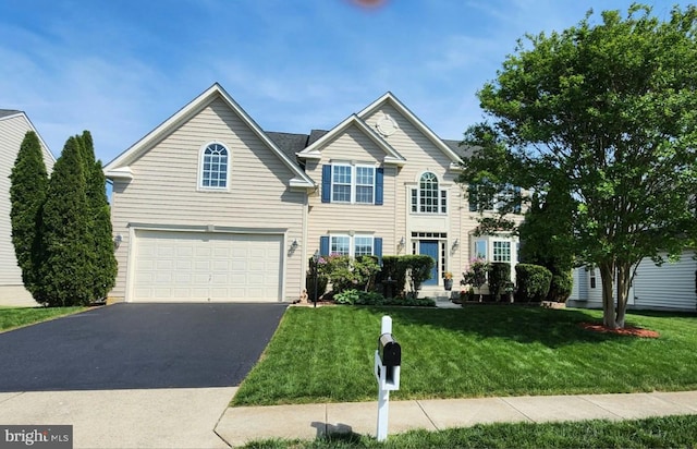 traditional home with a garage, driveway, and a front yard