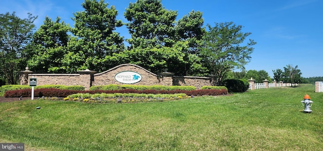 community sign with a lawn and fence