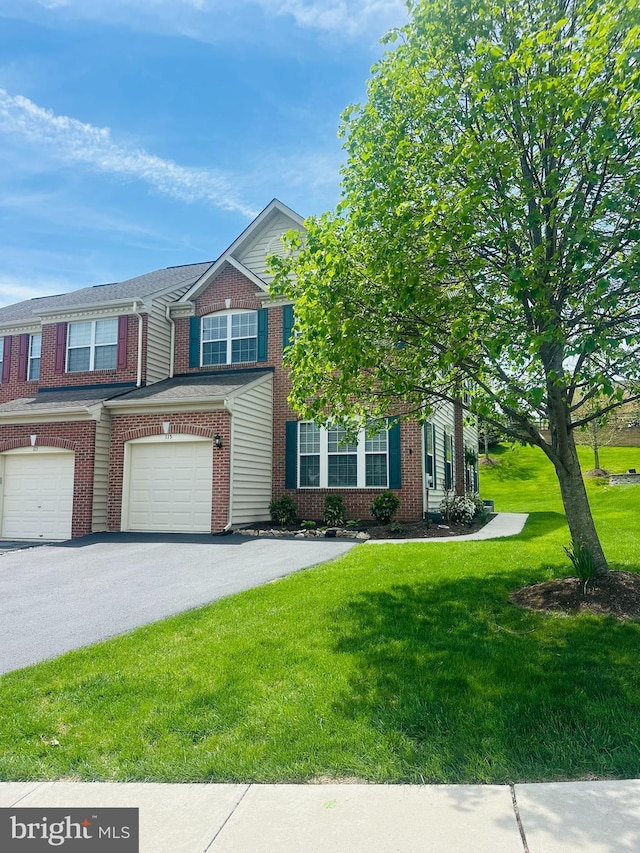 multi unit property featuring brick siding, an attached garage, driveway, and a front lawn