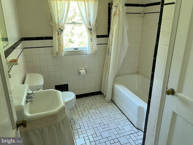 full bathroom with shower / bath combination with curtain, tile walls, a sink, a wainscoted wall, and toilet