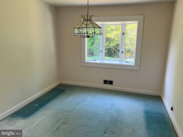 carpeted spare room featuring visible vents, baseboards, and plenty of natural light