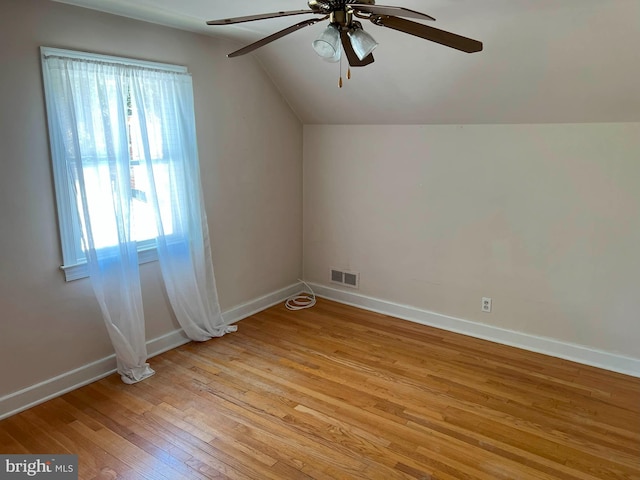 additional living space featuring a ceiling fan, visible vents, baseboards, light wood finished floors, and lofted ceiling