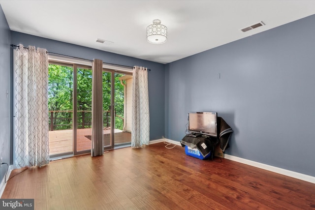 empty room with visible vents, baseboards, and wood finished floors