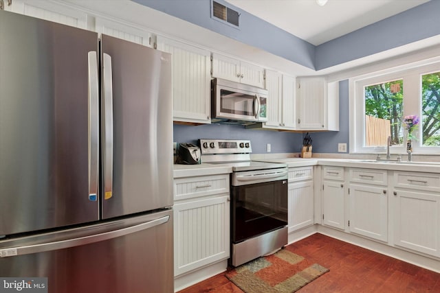 kitchen with dark wood-type flooring, light countertops, visible vents, and stainless steel appliances