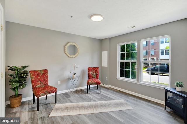 living area with baseboards, wood finished floors, and visible vents