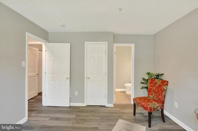 living area featuring baseboards and wood finished floors
