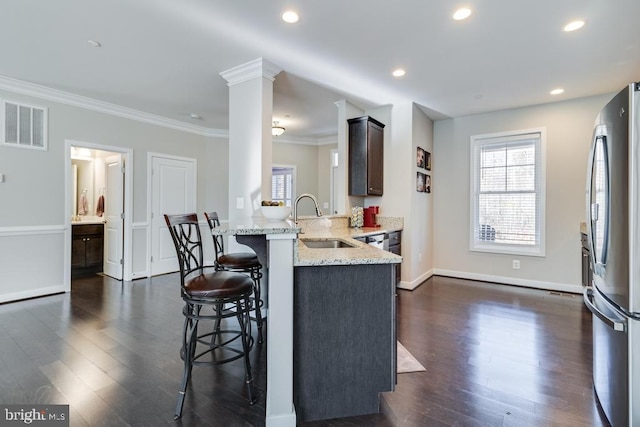 12815 Breyer Pl, Hughesville, MD 20637 - kitchen featuring dark wood-style flooring, a sink, a breakfast bar area, freestanding refrigerator, and visible vents