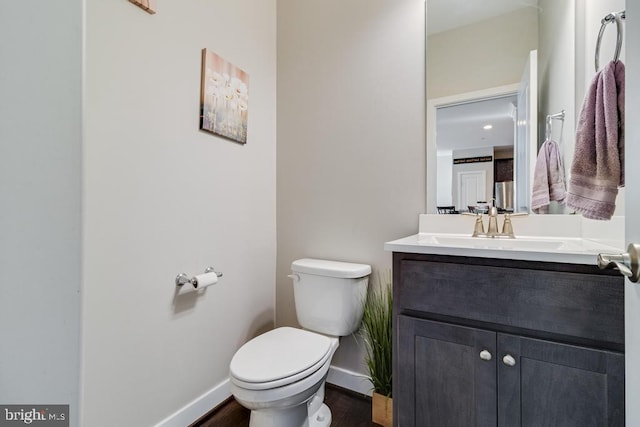 12815 Breyer Pl, Hughesville, MD 20637 - half bathroom with baseboards, vanity, toilet, and wood finished floors