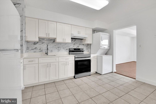 3709 S George Mason Dr Unit 1109E, Falls Church, VA 22041 - kitchen with stacked washer and dryer, stainless steel electric range oven, a sink, freestanding refrigerator, and under cabinet range hood