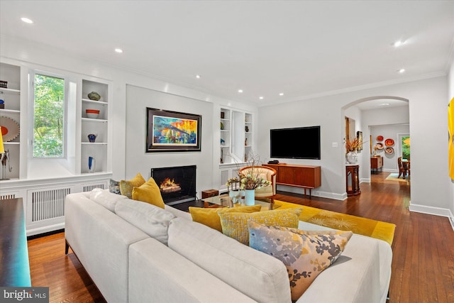 2871 Audubon Ter NW, Washington, DC 20008 - living room featuring a warm lit fireplace, arched walkways, hardwood / wood-style floors, and built in features