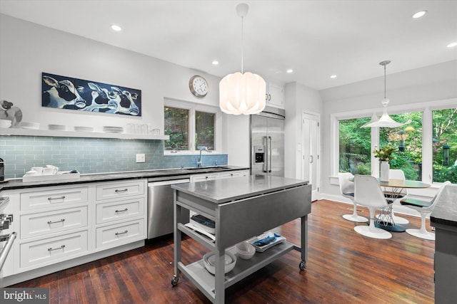 2871 Audubon Ter NW, Washington, DC 20008 - kitchen with a sink, dark countertops, stainless steel appliances, white cabinetry, and backsplash