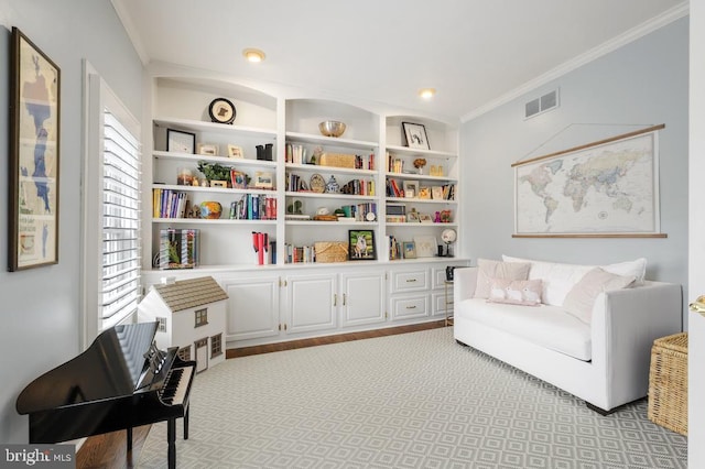 sitting room with ornamental molding, built in shelves, and visible vents