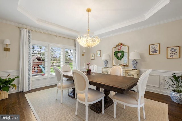 dining room with a tray ceiling, a chandelier, and ornamental molding