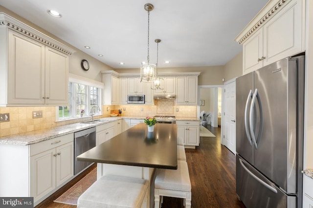 kitchen featuring dark wood-type flooring, a sink, backsplash, and stainless steel appliances