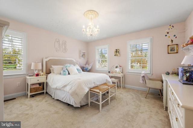 bedroom featuring an inviting chandelier, baseboards, and light carpet