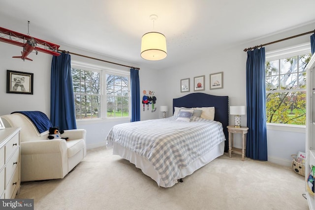 bedroom featuring baseboards, multiple windows, and light carpet