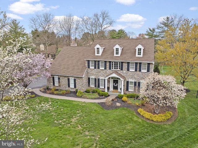 view of front of home with a front yard and stone siding