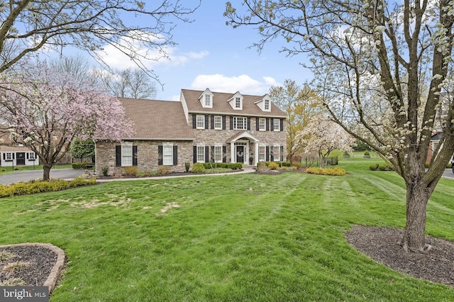 view of front of property with a front yard and stone siding
