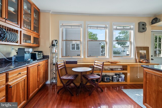 dining area with crown molding and dark wood-style flooring