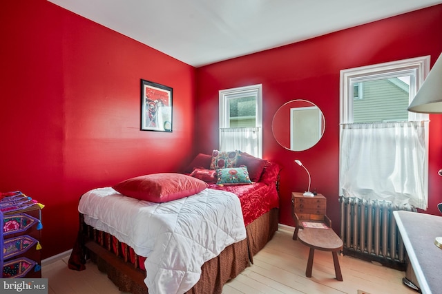 bedroom featuring light wood-style floors and radiator
