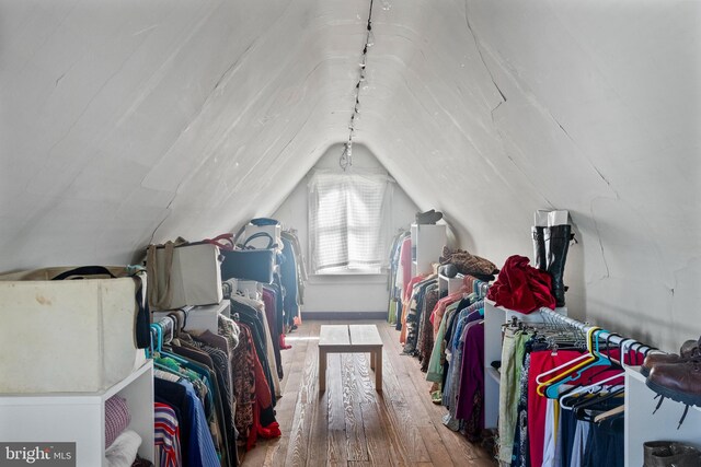 walk in closet featuring wood finished floors and lofted ceiling