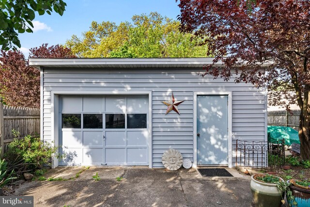 view of outbuilding featuring fence and an outdoor structure
