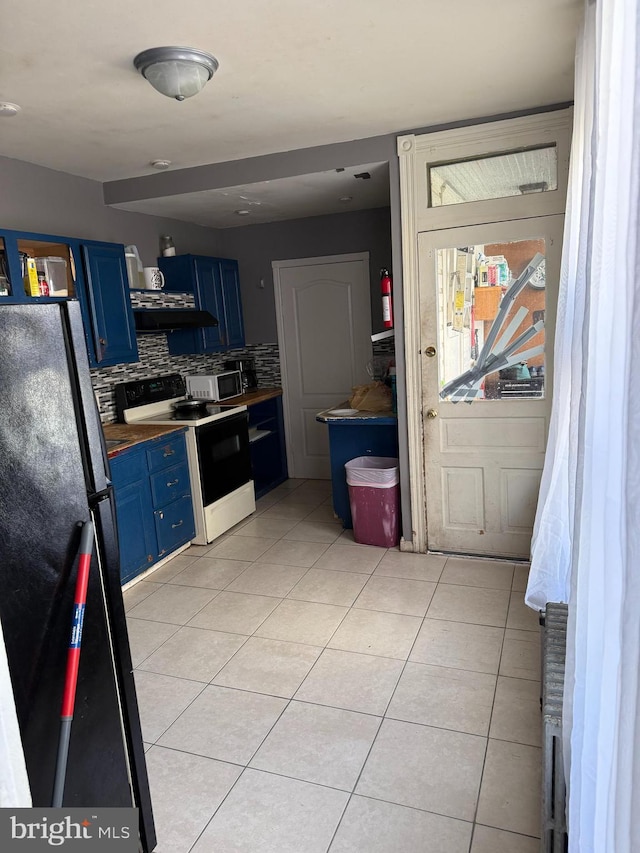 kitchen featuring freestanding refrigerator, light tile patterned floors, tasteful backsplash, range with electric stovetop, and blue cabinets