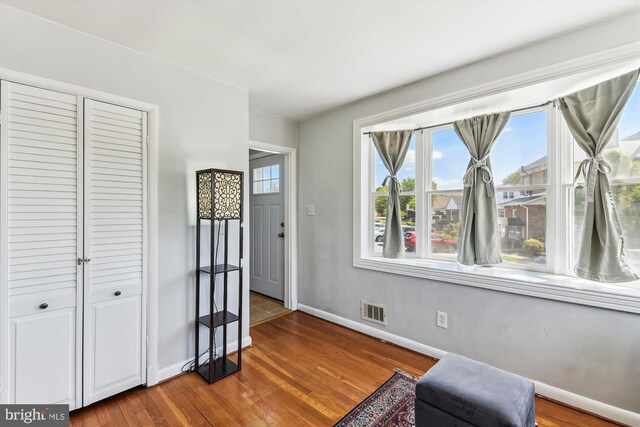 living area with baseboards, visible vents, and wood finished floors