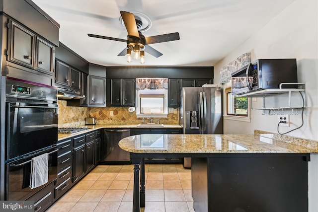 kitchen featuring dark cabinets, decorative backsplash, ceiling fan, and black appliances